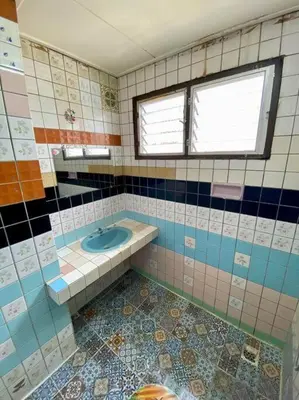 a tiled bathroom with a sink and a window at Ratanawong Place 407 in Bangkok