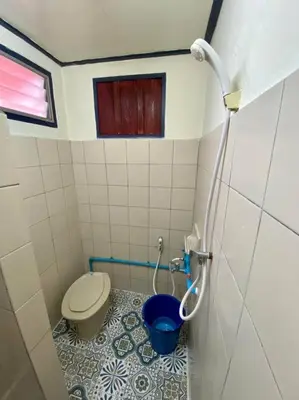 a bathroom with a toilet and a blue bucket at Ratanawong Place 559 in Bangkok