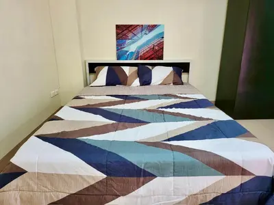 a bed with a colorful quilt on it in a bedroom at My Space 77 in Ban Khlong Khwang Klang