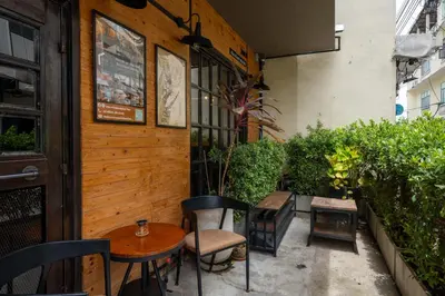 a patio with a table and chairs in front of a building at House of Machine Boutique Hotel in Bangkok
