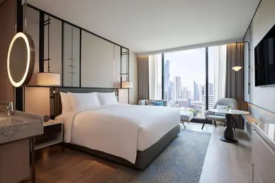 a bedroom with a large white bed and a large window at dusitD2 Samyan Bangkok in Bangkok