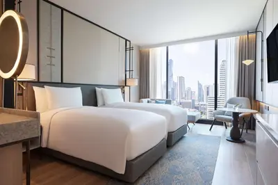 a hotel room with two beds and a large window at dusitD2 Samyan Bangkok in Bangkok