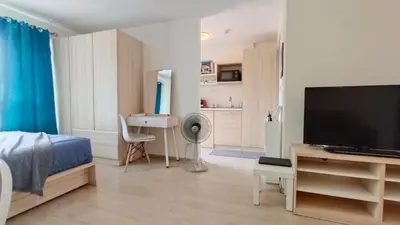 a bedroom with a bed and a flat screen tv at Elio Del Ray in Bangkok