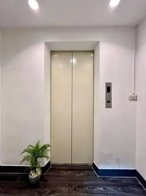 a hallway with a glass door and a potted plant at DiscoveryHome at Pratunam market in Bangkok