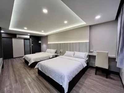 a hotel room with two beds and a desk at DiscoveryHome at Pratunam market in Bangkok