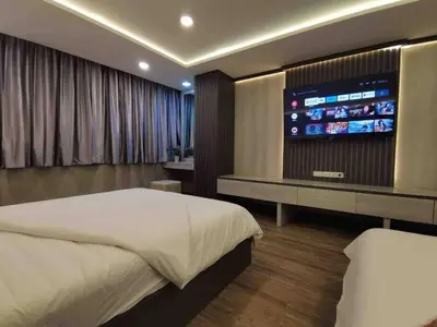 a bedroom with a bed and a flat screen tv at DiscoveryHome at Pratunam market in Bangkok