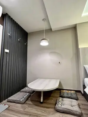 a room with a table and some pillows on the floor at DiscoveryHome at Pratunam market in Bangkok