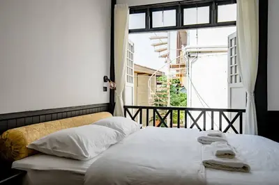 a bed sitting in a room with a window at Haheng House in Bangkok