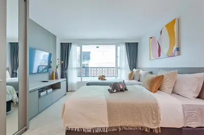 a bedroom with a large bed and a television at GM Residence in Bangkok