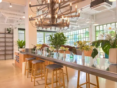 a bar in a restaurant with stools and a chandelier at Beat Hotel Bangkok in Bangkok