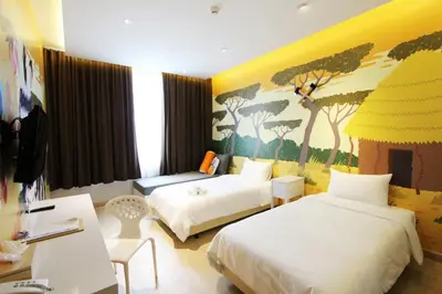 a hotel room with two beds and a painting on the wall at Beat Hotel Bangkok in Bangkok