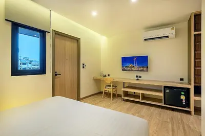 a bedroom with a bed and a desk and a television at Phra Nakhon Poshtel in Bangkok