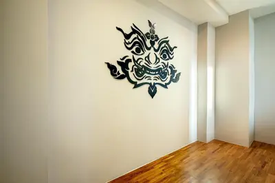 a mask on a wall in a room at Phra Nakhon Poshtel in Bangkok