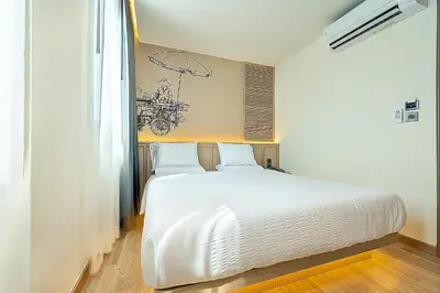 a bedroom with a large white bed in a room at Phra Nakhon Poshtel in Bangkok