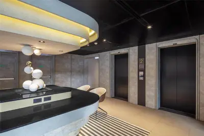 a lobby with black walls and a black counter and chairs at Best Western Ratchada Hotel in Bangkok
