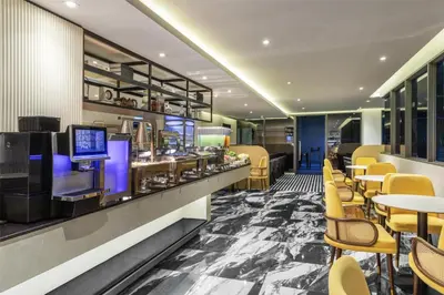 a restaurant with a bar and tables and chairs at Best Western Ratchada Hotel in Bangkok