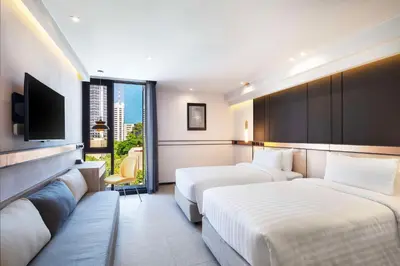 a hotel room with two beds and a flat screen tv at Best Western Ratchada Hotel in Bangkok