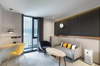 a living room with a couch and a table and chairs at Best Western Ratchada Hotel in Bangkok