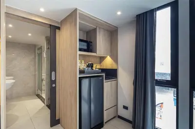 a kitchen with wooden cabinets and a counter top at Best Western Ratchada Hotel in Bangkok