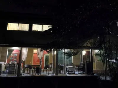 a patio with chairs and tables at night at นอนในสวน รีสอร์ท in Bangkok