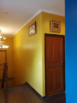 a hallway with a door and a yellow wall at นอนในสวน รีสอร์ท in Bangkok