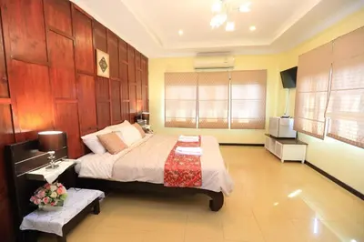 a bedroom with a bed and a bench in it at นอนในสวน รีสอร์ท in Bangkok