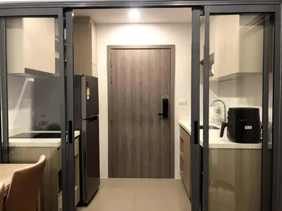 a kitchen with a door leading into a kitchen with a counter at NEST Sukhumvit71 BTS - Pool, Fitness, Parking, Wifi in Bangkok