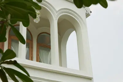a window on the side of a white house at Arpo Pool Villa Riverside Bangkok in Bangkok