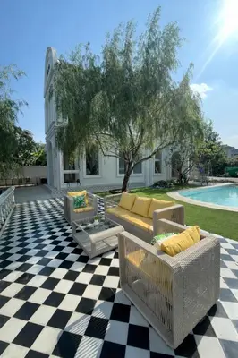 a patio with couches on a checkered floor at Arpo Pool Villa Riverside Bangkok in Bangkok