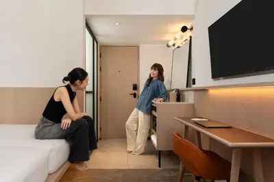 two women are standing in a hotel room at ASAI Bangkok Sathorn in Bangkok
