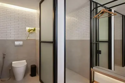 a bathroom with a toilet and a glass door at ASAI Bangkok Sathorn in Bangkok