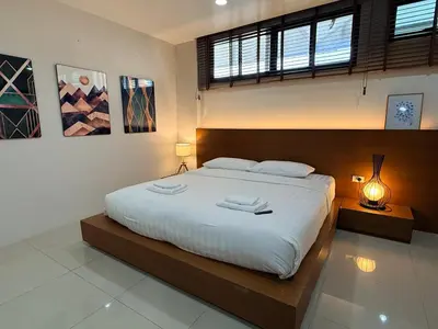 a bedroom with a large bed with two towels on it at Joyful Modern Home with Foods and MRT Rama 9 Nearby in Bangkok