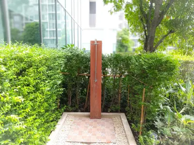 a metal pole sitting in front of a hedge at Rooms bangkok nearby Onnut bts in Amphoe Phra Khanong