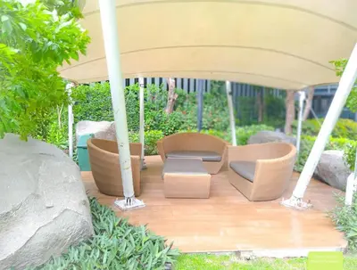 a group of chairs under an umbrella on a wooden deck at Rooms bangkok nearby Onnut bts in Amphoe Phra Khanong