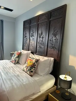 a bedroom with a bed with white sheets and pillows at Central Bangkok, 5 stars river view & characteristic decor in Bangkok