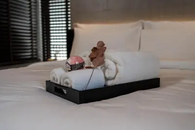 a bed with a pile of towels and a stuffed animal at EX2 Hotel in Ban Bang Khen (1)