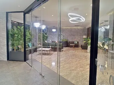 a lobby with glass walls and a waiting area at The 9 Residence Hotel in Bangkok