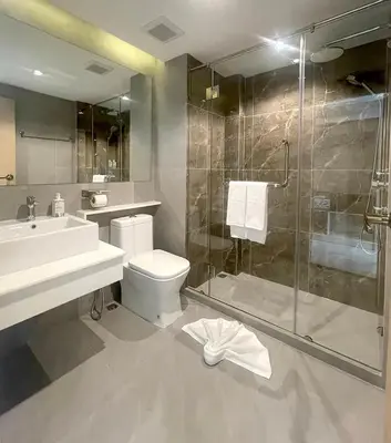 a bathroom with a shower and a toilet and a sink at The 9 Residence Hotel in Bangkok