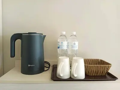 a tea kettle and two bottles of water on a counter at The 9 Residence Hotel in Bangkok