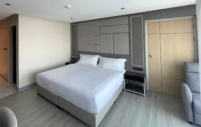 a bedroom with a large white bed and a couch at The 9 Residence Hotel in Bangkok
