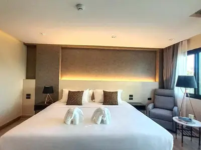 a bedroom with a large white bed with two towels on it at The 9 Residence Hotel in Bangkok
