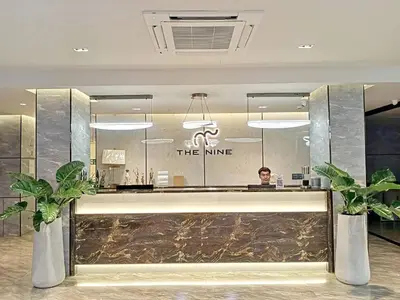 a man sitting at a counter in a hotel lobby at The 9 Residence Hotel in Bangkok