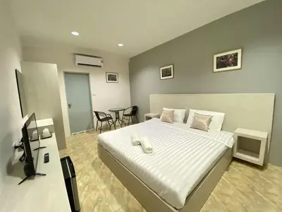 a bedroom with a bed and a desk with a television at บ้านสายสิริ in Ban Bang Talat
