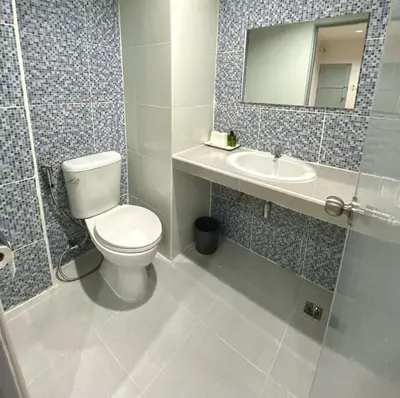 a bathroom with a toilet and a sink and a mirror at บ้านสายสิริ in Ban Bang Talat