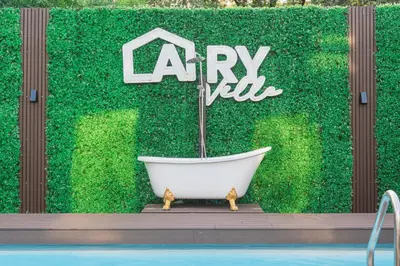 a bath tub sitting in front of a green hedge at Bangkok Cozy Garden Pool Villa Sukhumvit in Amphoe Phra Khanong
