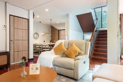 a living room with a couch and a table at Bangkok Cozy Garden Pool Villa Sukhumvit in Amphoe Phra Khanong