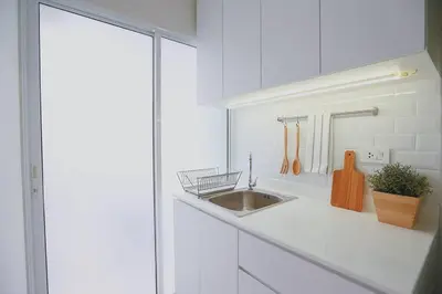 a white kitchen with a sink and a counter at Minimal Cozy Room near Chatuchak Weekend Market #1 in Bangkok