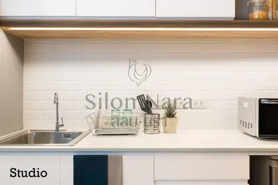 a kitchen counter with a sink and a microwave at Silom Nara in Bangkok