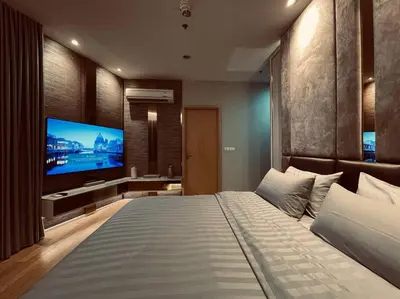 a bedroom with a large bed and a flat screen tv at Luxury 2BR on the Clouds in Prime area Bangkok in Bangkok