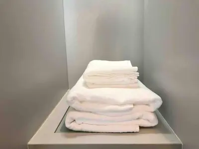 a stack of white towels sitting on a shelf at 1BR Luxury Condo 50m to Thonglor BTS station in Bangkok